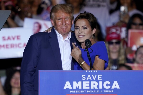 FILE - Arizona Republican gubernatorial candidate Kari Lake, right, speaks as former President Donald Trump listens during a rally, Oct. 9, 2022, in Mesa, Ariz. While vice presidential candidates typically aren't tapped until after a candidate has locked down the nomination, Trump's decisive win in the Iowa caucuses and the departure of Florida Gov. Ron DeSantis from the race has only heightened what had already been a widespread sense of inevitability. Lake is considered a close ally of the former president who is among those being considered for the job. (AP Photo/Matt York, File)